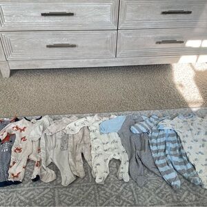 Eight long sleeve onesies/ footie pajamas by Gerber in a size newborn.